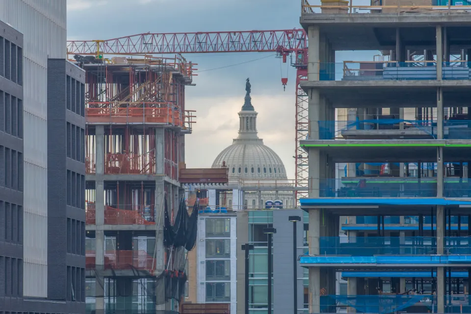 View of Washington D.C. Capitol dome through high-rise buildings in various states of construction.